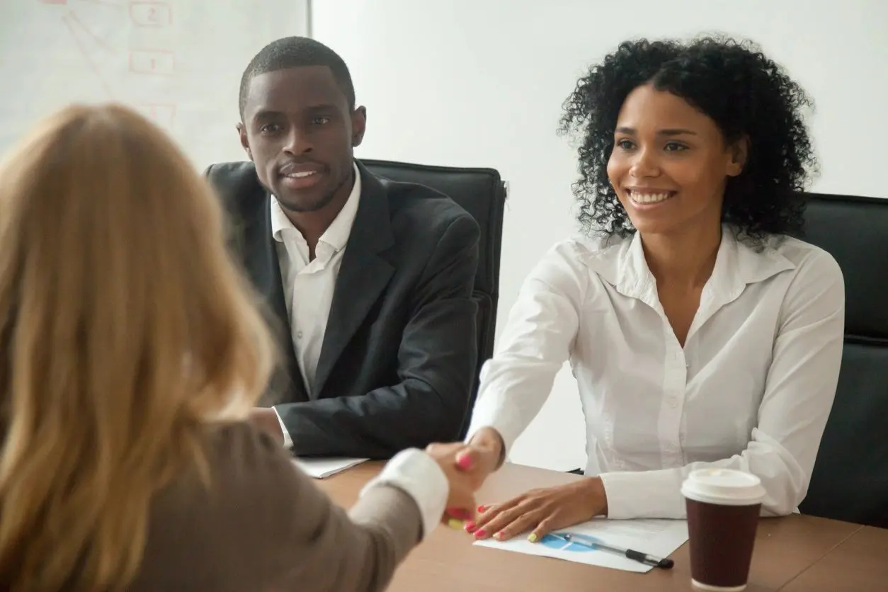 Two professionals shaking hands during a business meeting.