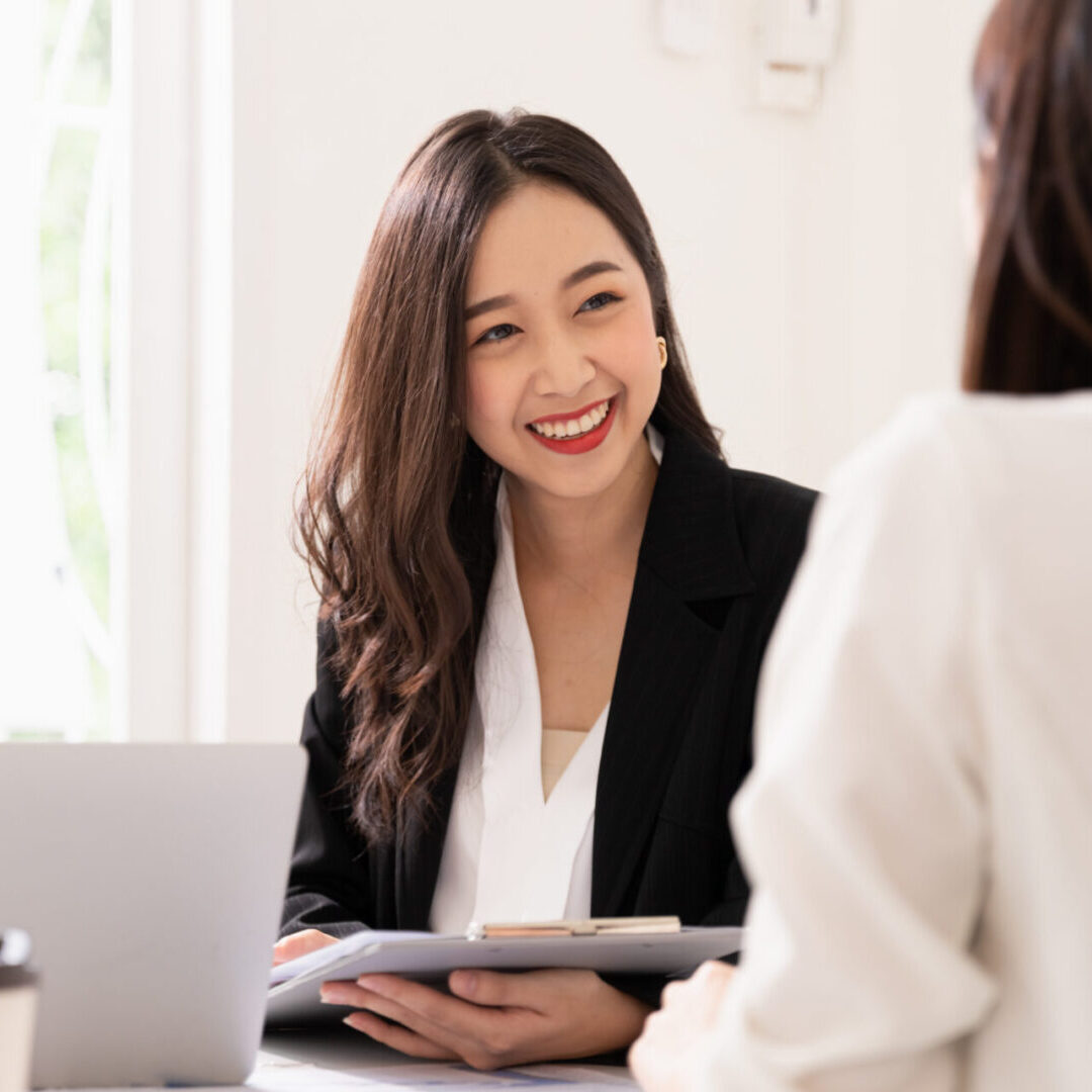 A young attractive asian woman is interviewing for a job. Her interviewers are diverse. Human resources manager conducting job interview with applicants in office Professional women having a business meeting.