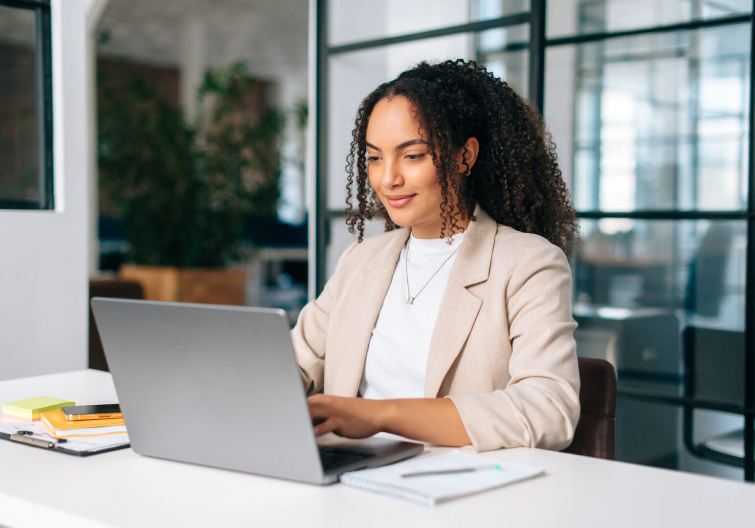 Woman working on laptop in modern office.
